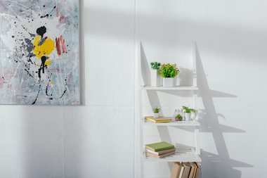 Vægdekoration kan være mange ting - Her det en reol med pynteting og en plakat